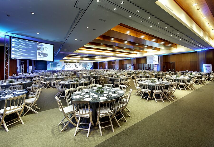 Eurostars Madrid Tower Hotel Exterior photo The photo shows a spacious banquet hall or conference room set up for an event. There are several round tables arranged across the floor, each with elegant table settings, including plates, cutlery, and glasses. The decor features neutral tones, and 