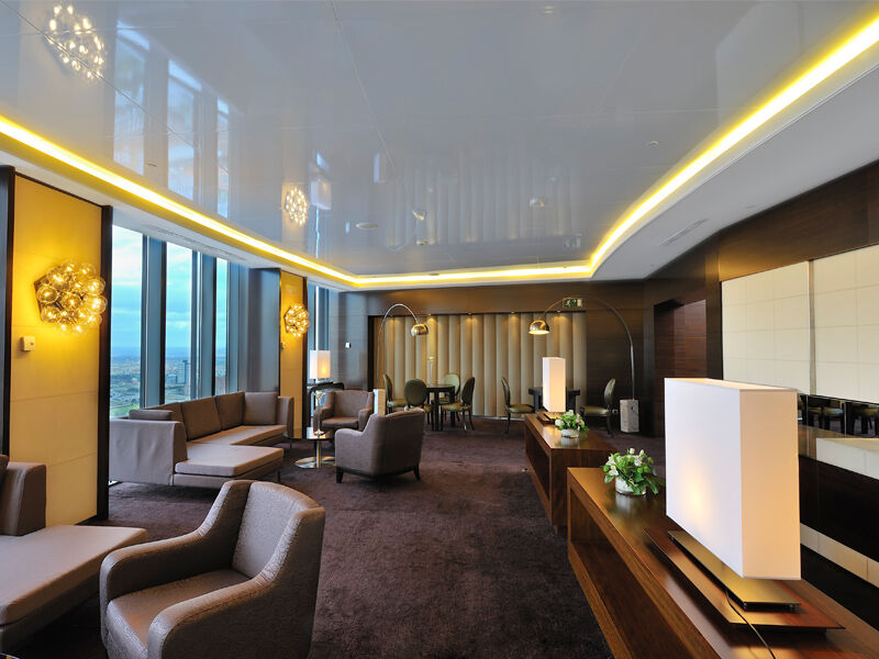 Eurostars Madrid Tower Hotel Exterior photo The photo shows a modern, elegantly designed lounge or reception area. It features large windows that provide a panoramic view, allowing natural light to fill the space. The interior is furnished with contemporary couches and armchairs in neutral ton